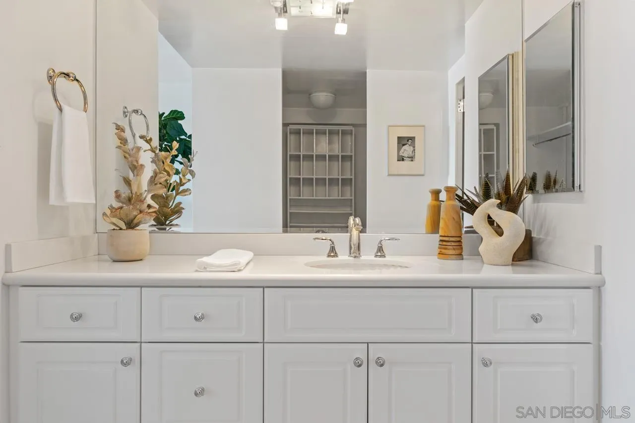939 Coast Boulevard, Unit 20C La Jolla, CA 92037 - Photo 14 of 25 a bathroom with cabinets sink and a mirror