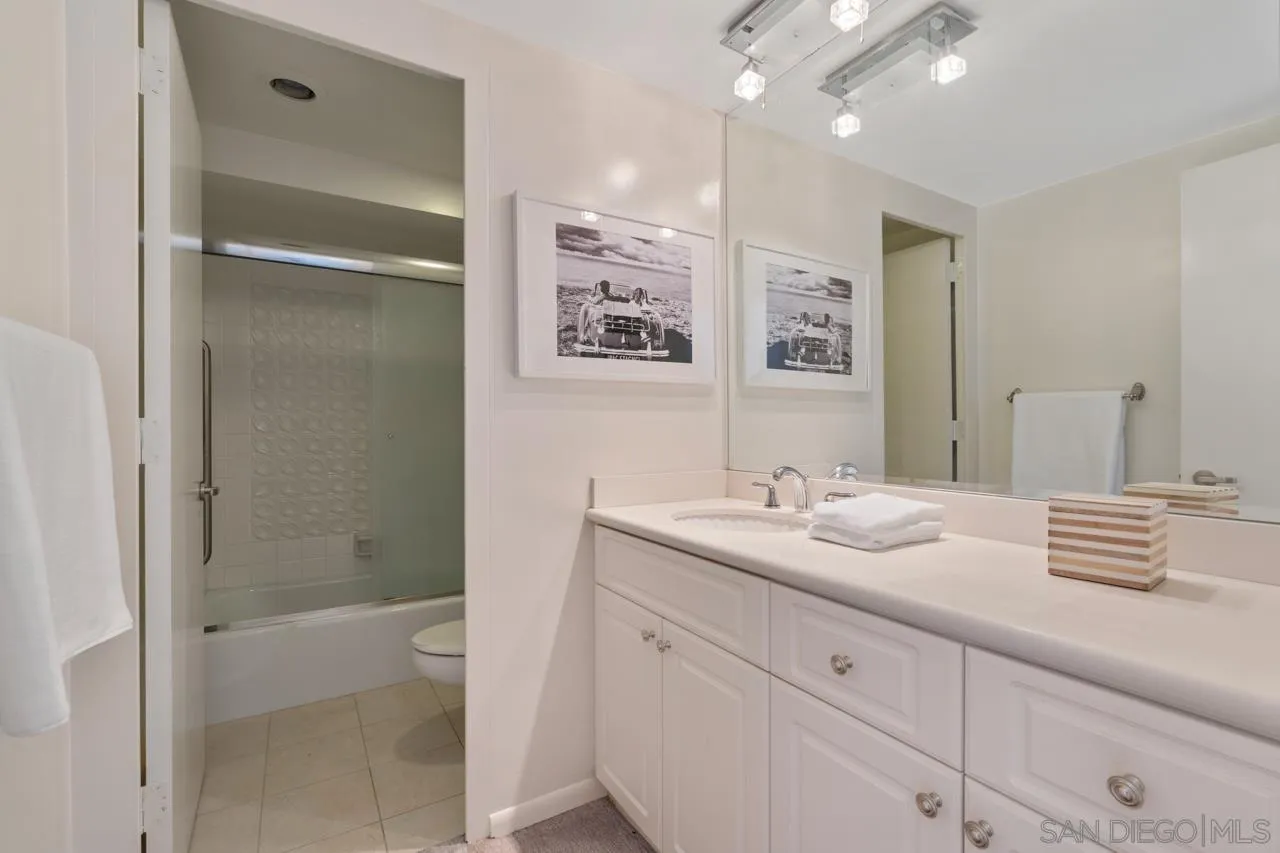 939 Coast Boulevard, Unit 20C La Jolla, CA 92037 - Photo 19 of 25 a bathroom with a sink a mirror and a shower