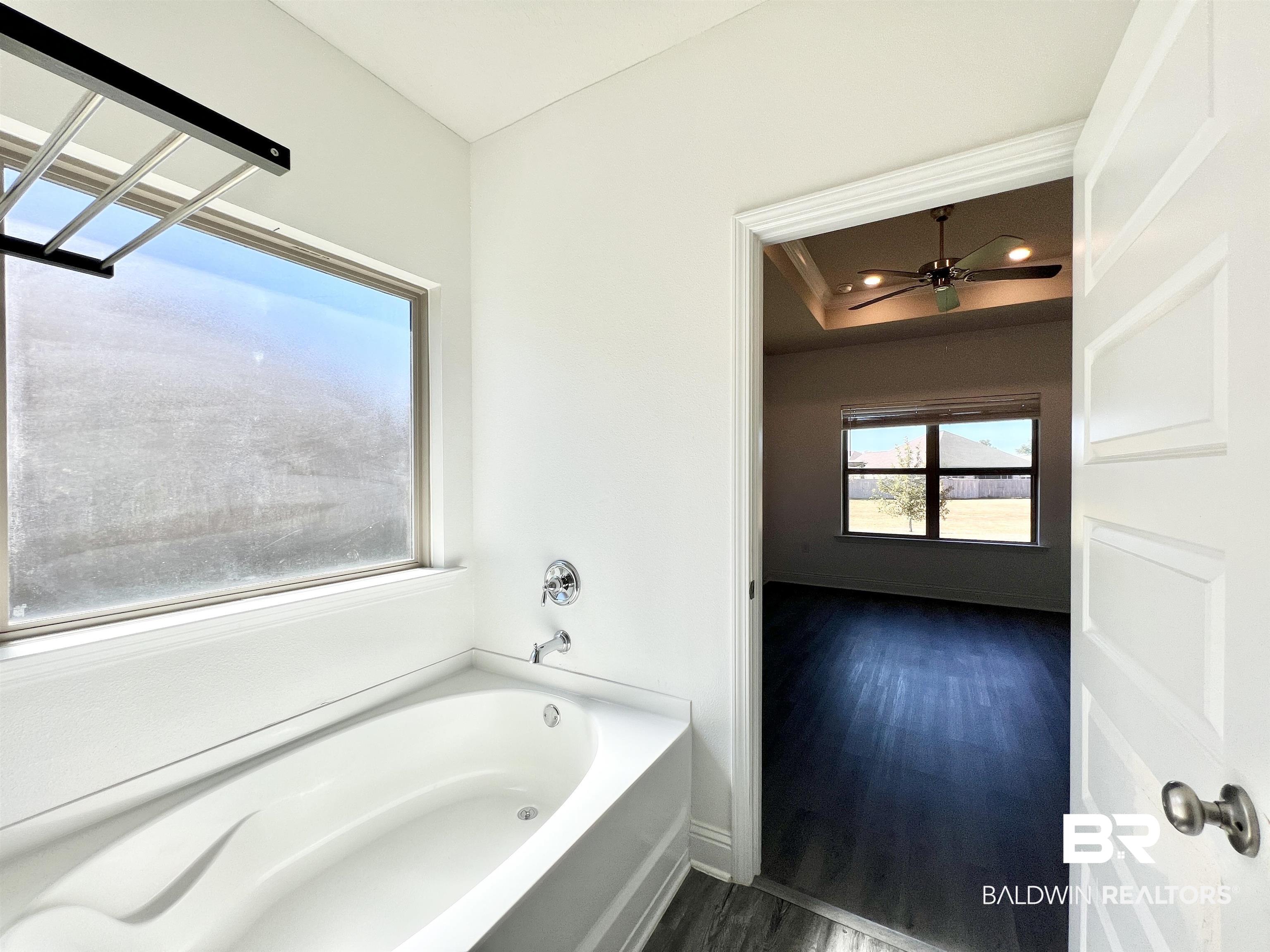 24785 Slater Mill Road Daphne, AL 36526 - Photo 33 of 46 Bathroom featuring hardwood / wood-style floors, a bathtub, and ceiling fan