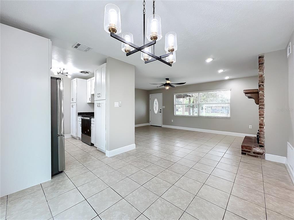 600 Ridgefield Avenue Ocoee, FL 34761 - Photo 19 of 45 Electric Fireplace in living room with ceramic tile floors, upgraded baseboards, new ceiling fan and insulated beveled glass front door opens to dinging area and kitchen.