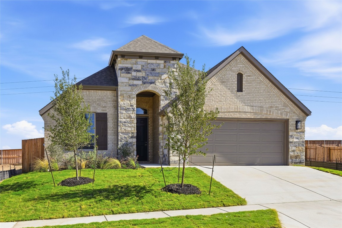 281 Grey Leaf Road Buda, TX 78610 - Photo 1 of 1 French provincial home featuring stone siding, brick siding, driveway, and roof with shingles