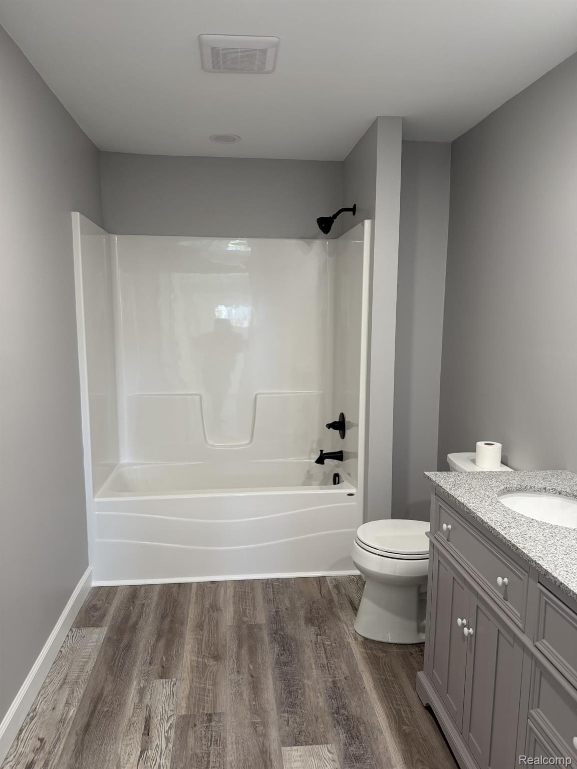 5614 West Marlette Road Marlette, MI 48453 - Photo 11 of 25 Bathroom featuring vanity, dark wood-type flooring, and bathtub / shower combination