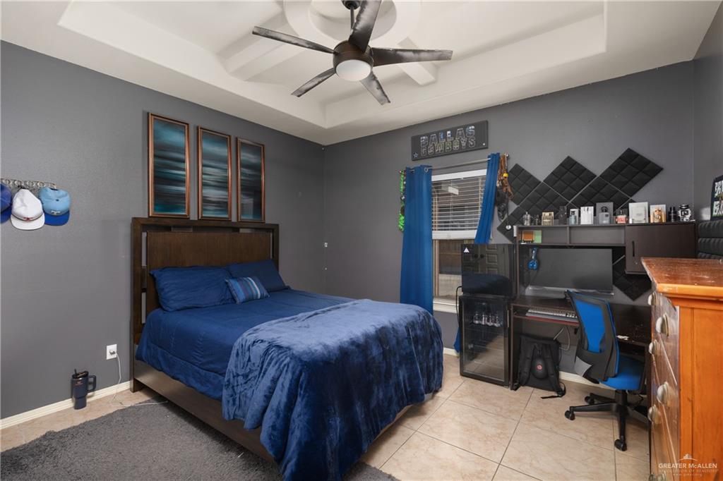 1502 Eucalyptus Street Weslaco, TX 78599 - Photo 13 of 24 a bedroom with a bed a desk and chair with a bookshelf