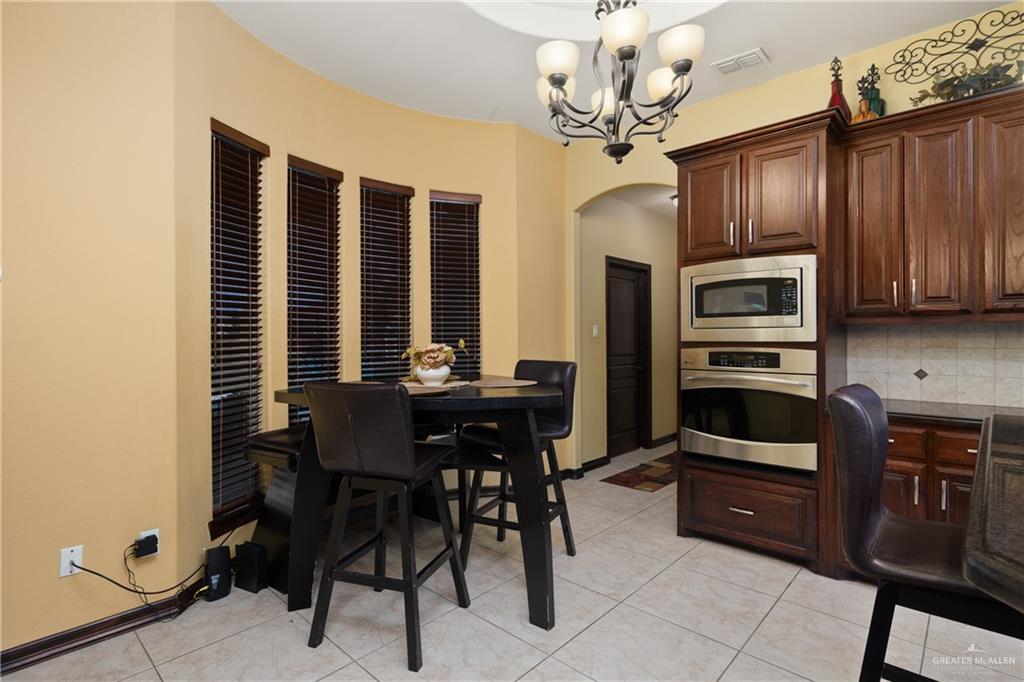 1502 Eucalyptus Street Weslaco, TX 78599 - Photo 8 of 24 a view of a dining room with furniture and chandelier
