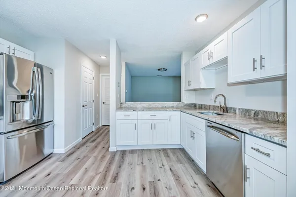 a kitchen with a sink stove refrigerator and cabinets