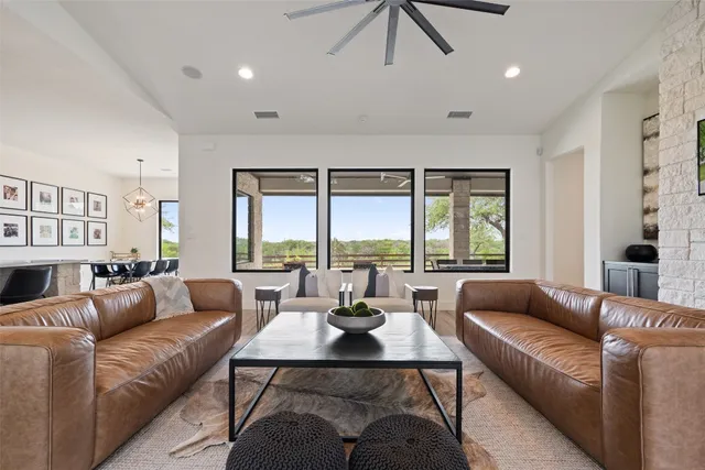 a living room with furniture wooden floor and a large window