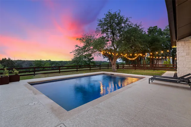 a front view of a house with swimming pool and a yard