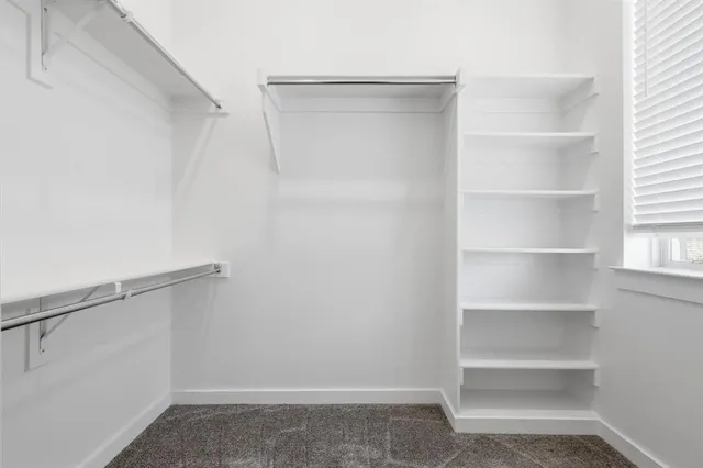 an empty room with an entryway and a window