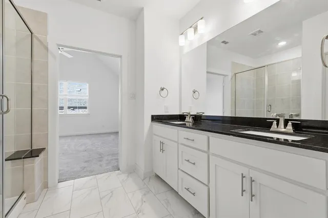 a bathroom with a double vanity sink and mirror