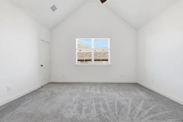 an empty room with a window and a ceiling fan