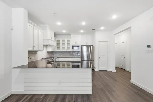 a living room with stainless steel appliances kitchen island granite countertop wooden floor and view living room