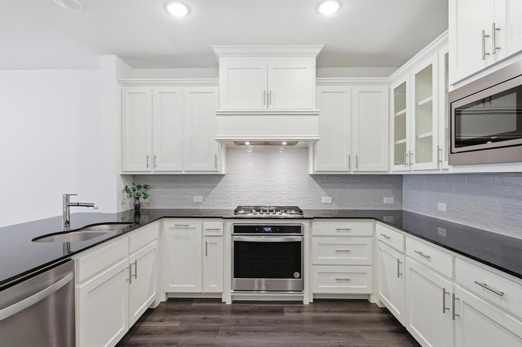 531 Cobblestone Lane Irving, TX 75039 - Photo 10 of 39 a kitchen with white cabinets and appliances