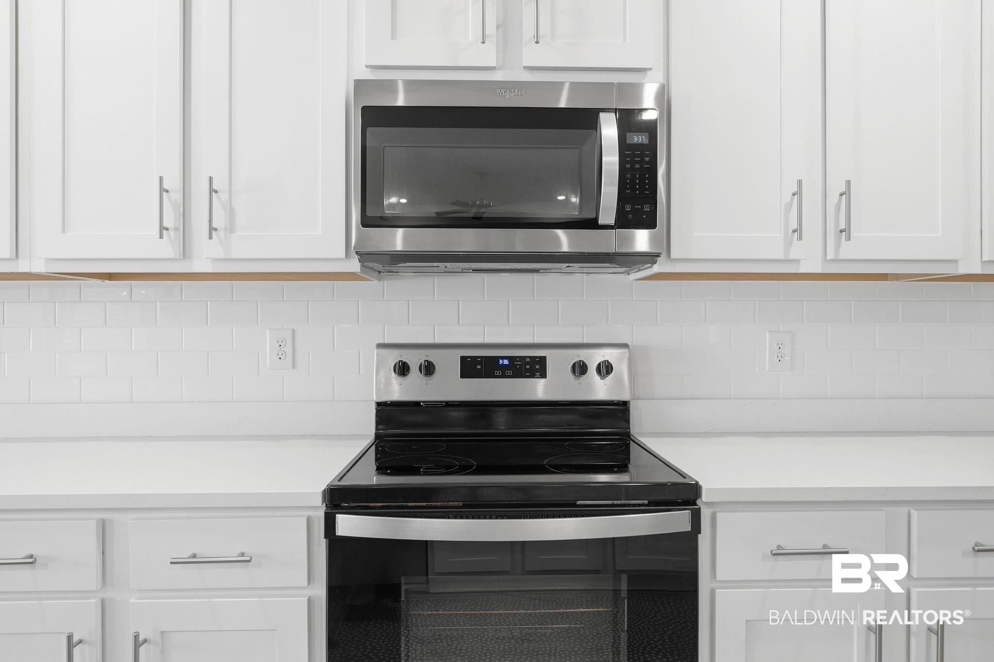 11123 Genuine Risk Circle Daphne, AL 36526 - Photo 19 of 67 Kitchen featuring stainless steel appliances, white cabinetry, and tasteful backsplash