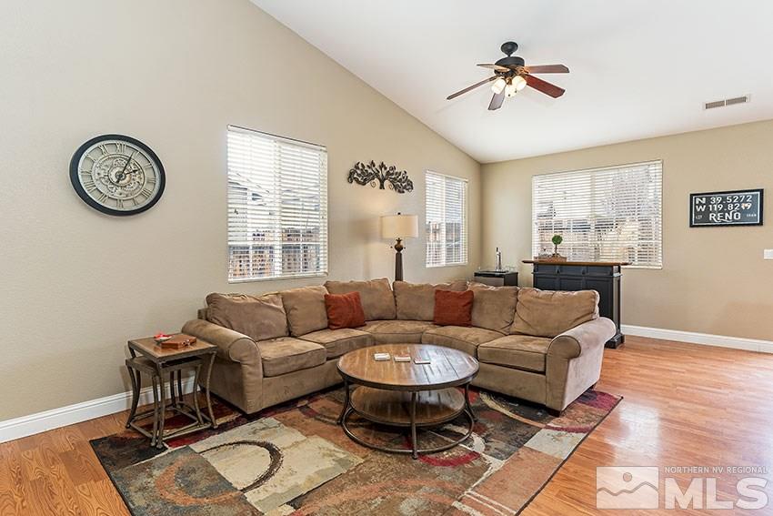 8945 Sorcha Street Reno, NV 89506 - Photo 3 of 25 a living room with furniture a clock on wall and a window