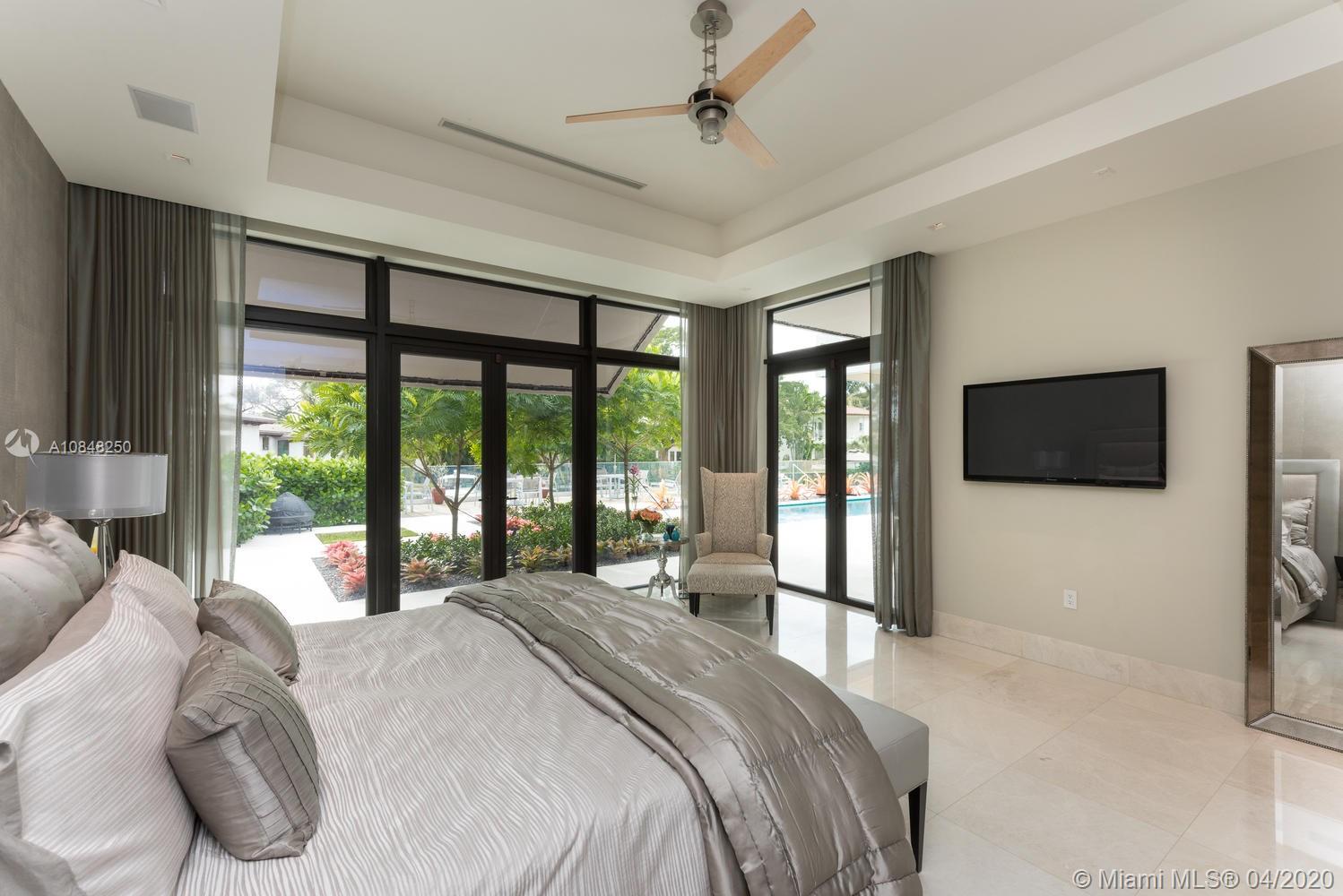 810 Jeronimo Drive Coral Gables, FL 33146 - Photo 11 of 32 a bedroom with a large bed and a large window