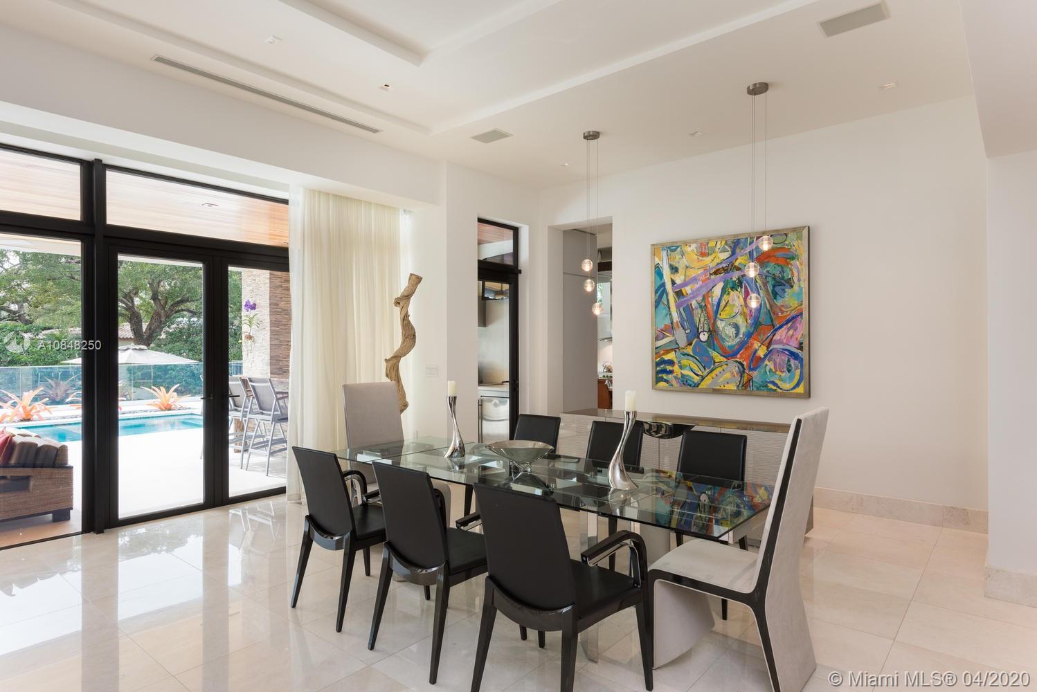 810 Jeronimo Drive Coral Gables, FL 33146 - Photo 21 of 32 a view of a dining room with furniture large windows and wooden floor