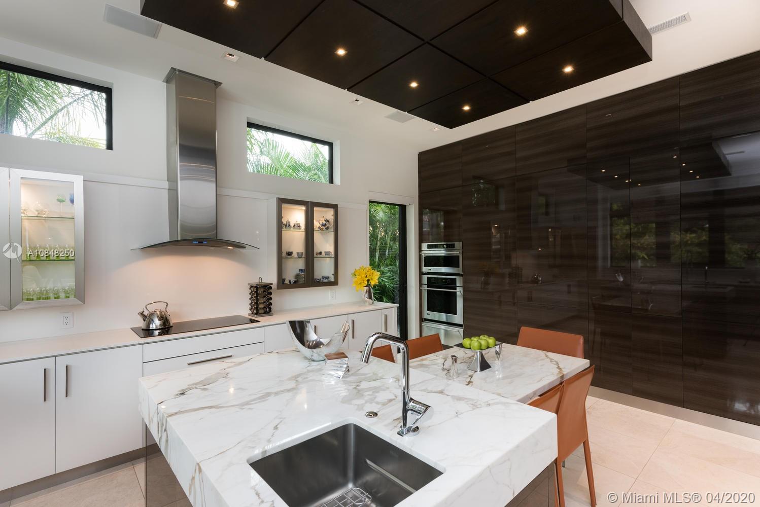 810 Jeronimo Drive Coral Gables, FL 33146 - Photo 23 of 32 a kitchen with stainless steel appliances kitchen island granite countertop a sink and a stove