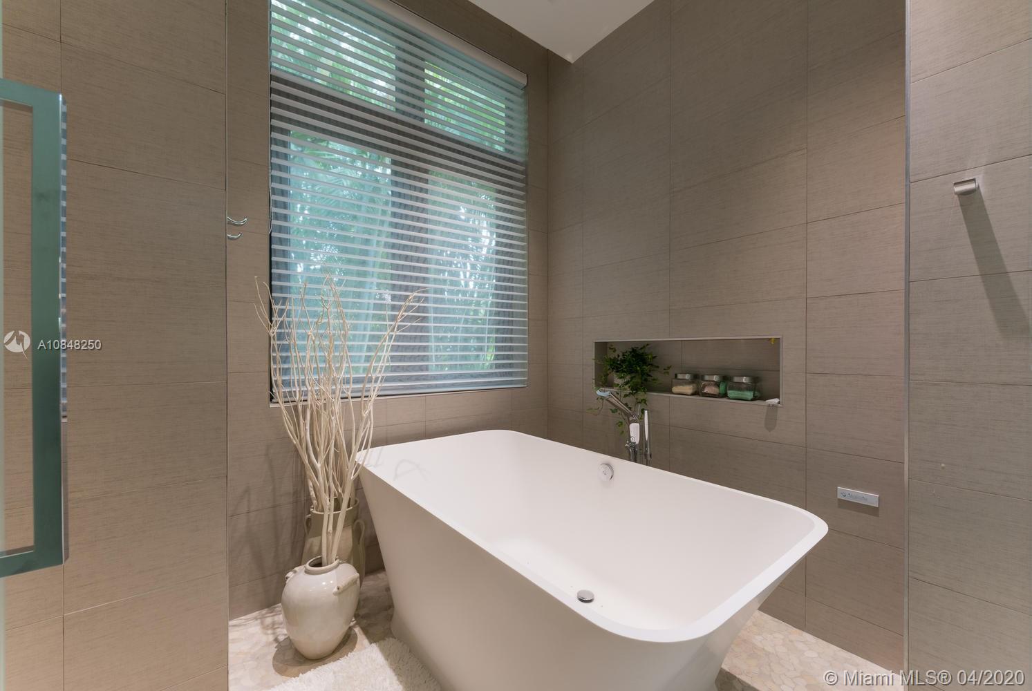 810 Jeronimo Drive Coral Gables, FL 33146 - Photo 9 of 32 a large white tub sitting in a bathroom next to a window