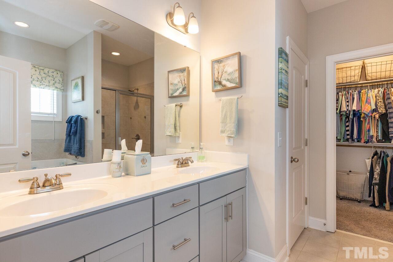3508 Jones Lake Road Fuquay-Varina, NC 27526 - Photo 14 of 41 a bathroom with double vanity sinks a large mirror and a shower