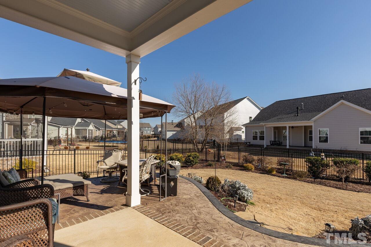 3508 Jones Lake Road Fuquay-Varina, NC 27526 - Photo 27 of 41 a view of a patio with couches chairs dining table and chairs under an umbrella