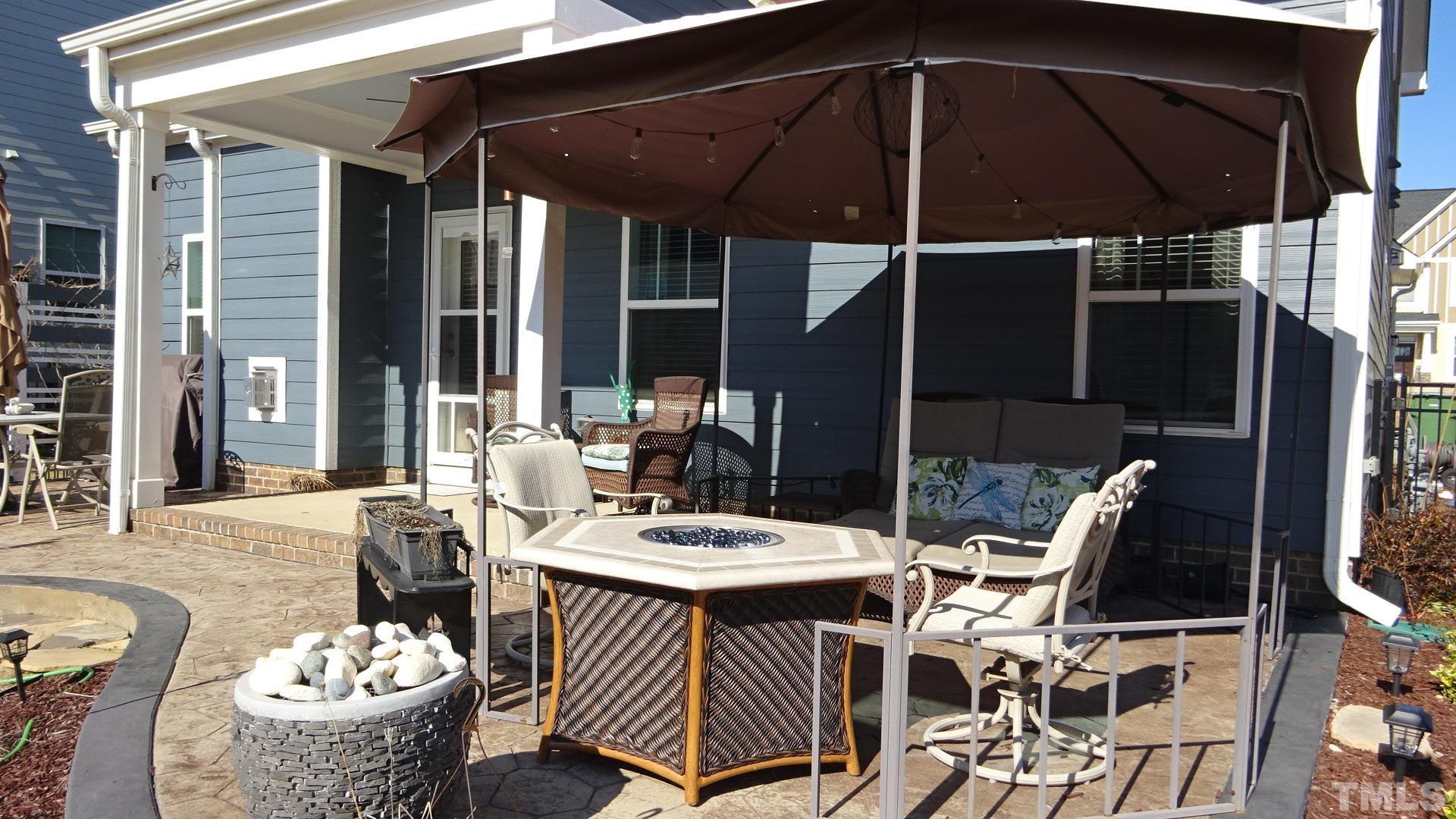 3508 Jones Lake Road Fuquay-Varina, NC 27526 - Photo 5 of 41 a view of a patio with table and chairs potted plants with wooden floor and floor to ceiling window