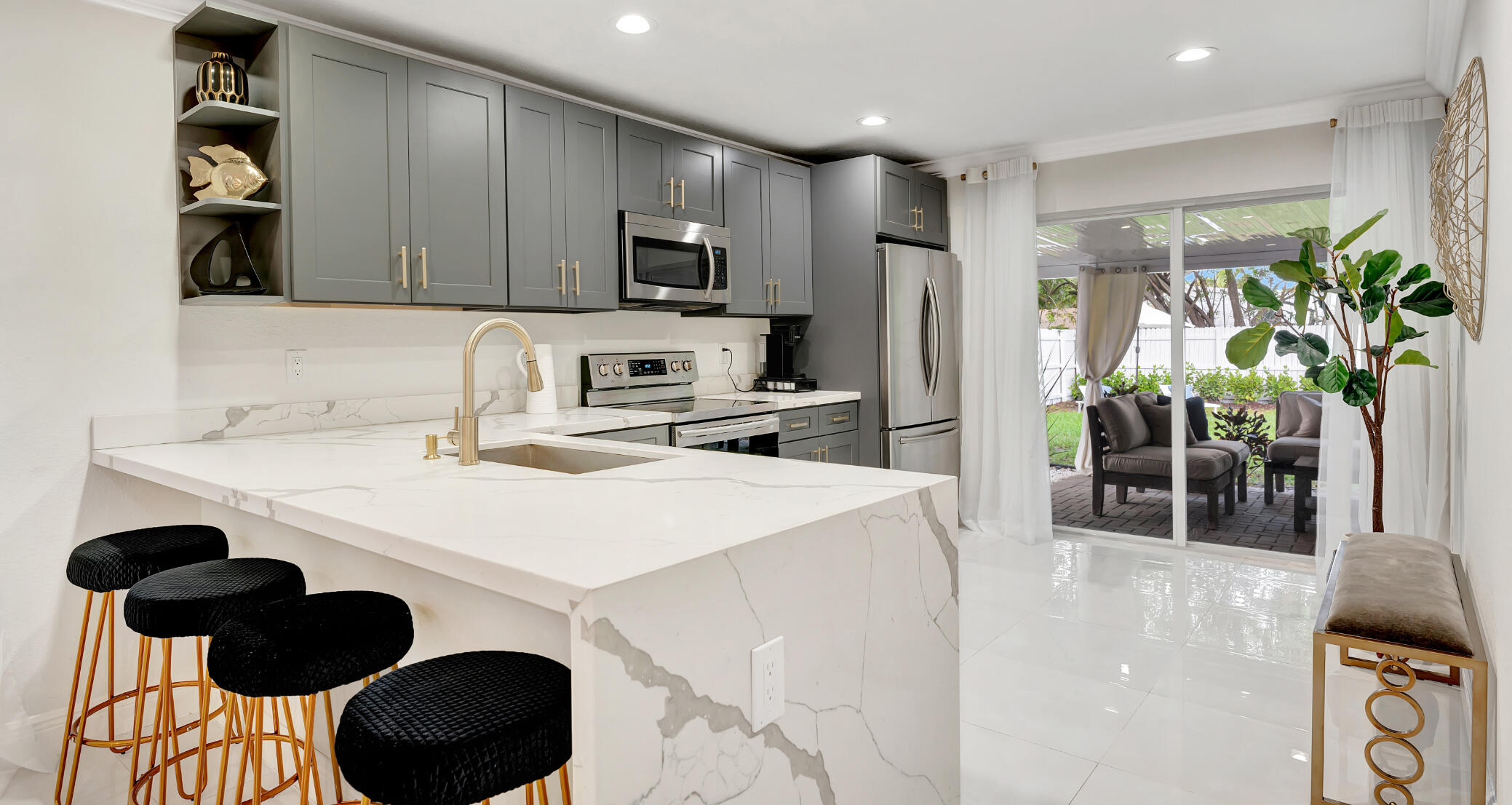 4901 Lincoln Road Delray Beach, FL 33445 - Photo 14 of 56 a kitchen with stainless steel appliances a stove a sink a microwave and cabinets