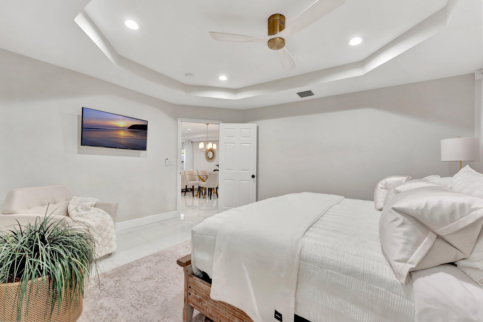 4901 Lincoln Road Delray Beach, FL 33445 - Photo 19 of 56 a spacious bedroom with a bed and a chandelier