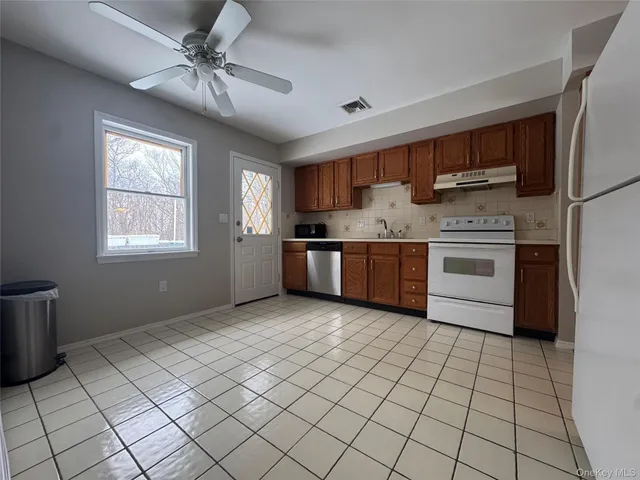 a kitchen with stainless steel appliances granite countertop a stove a sink and a refrigerator