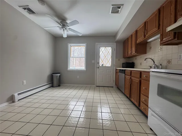 a kitchen with stainless steel appliances a sink cabinets and window