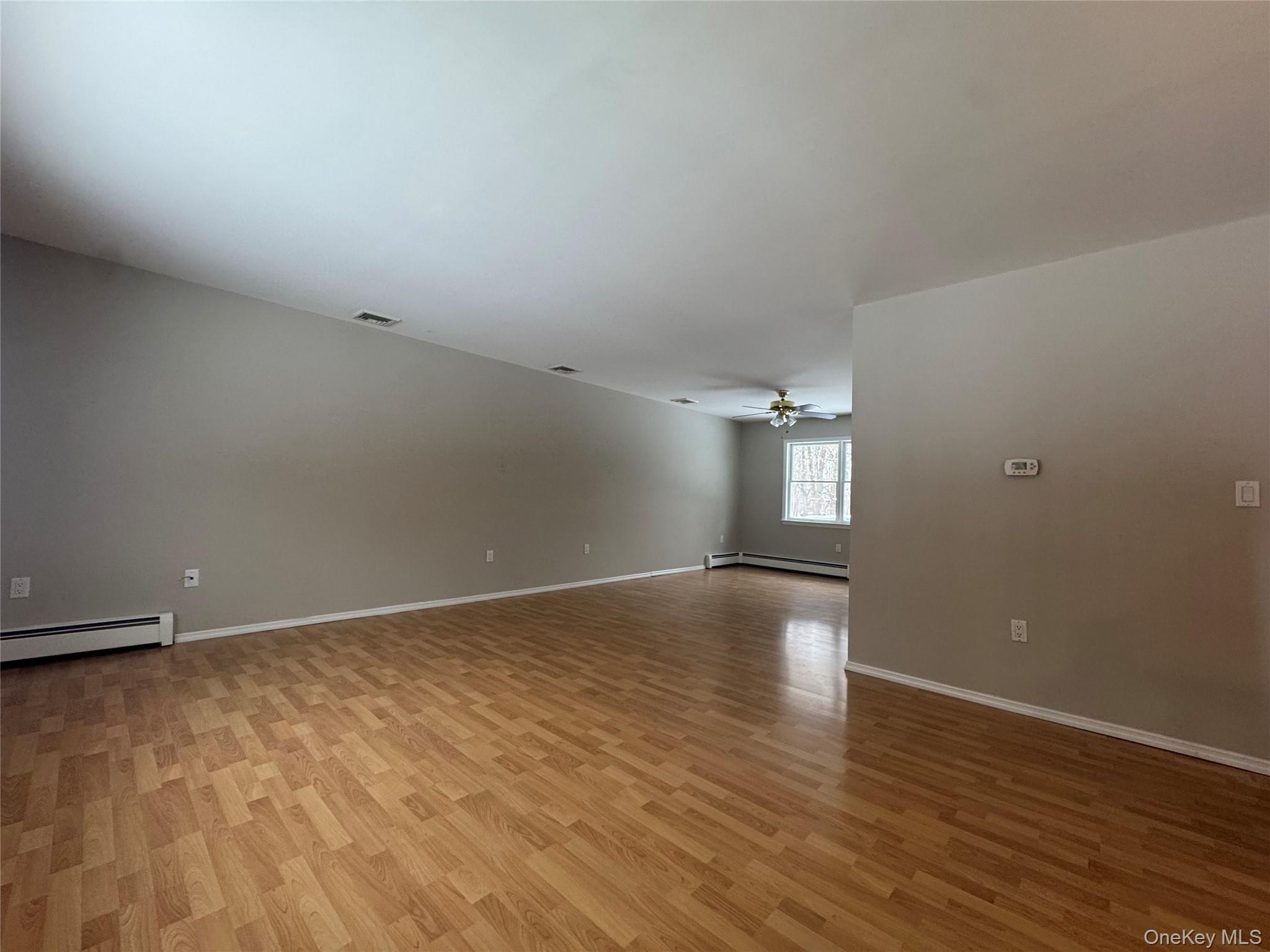 2217 Highway 300, Unit 1 Wallkill, NY 12589 - Photo 6 of 22 an empty room with wooden floor and windows