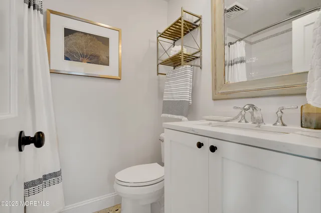a bathroom with a granite countertop sink a toilet and a mirror