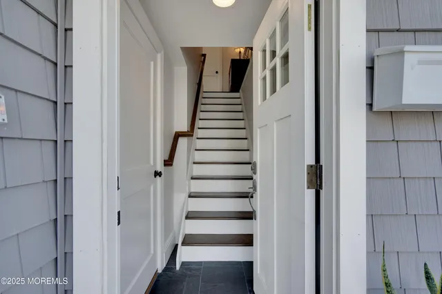 a view of staircase with white walls and white doors
