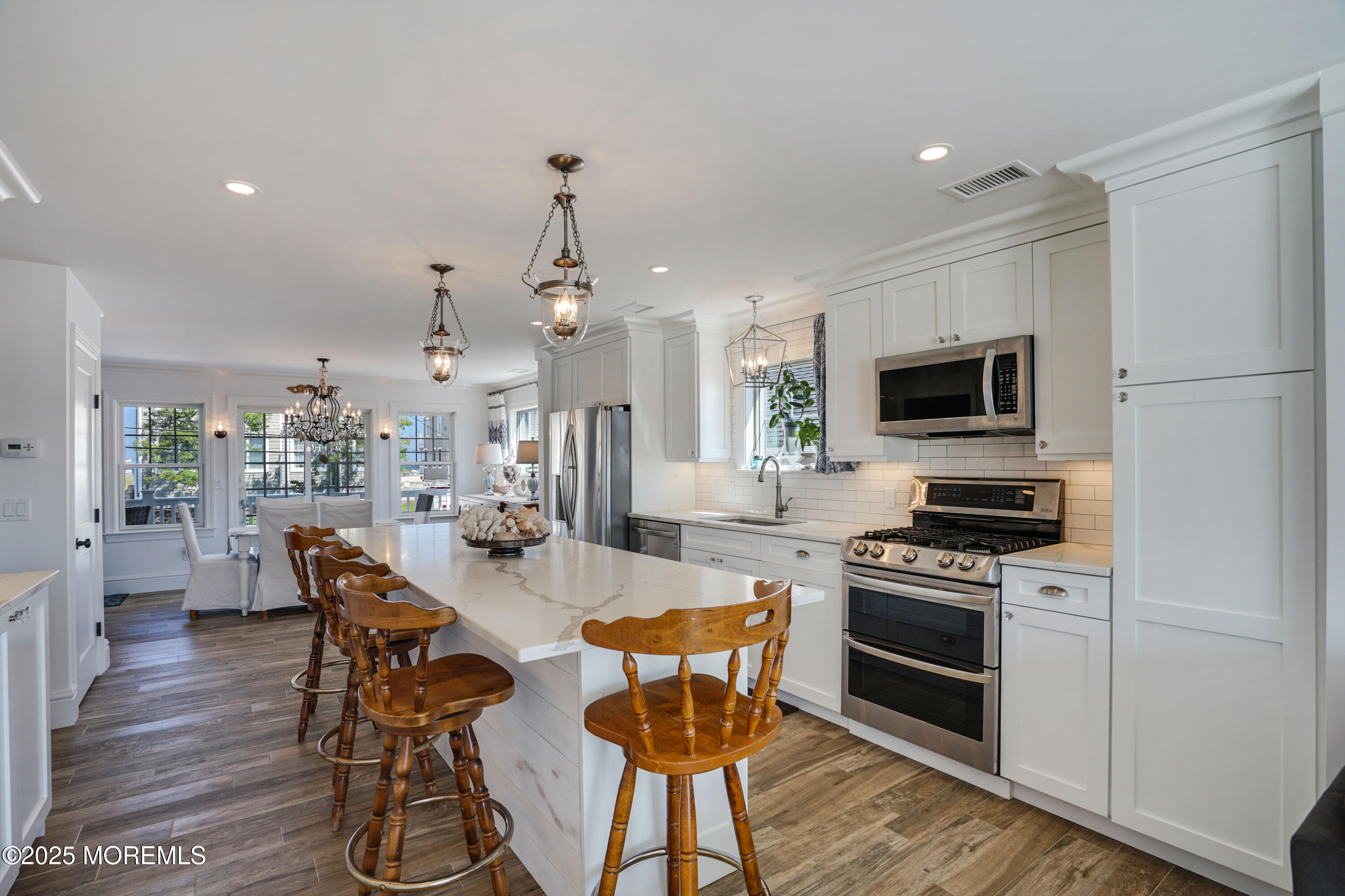 229 1st Avenue Manasquan, NJ 08736 - Photo 7 of 32 a kitchen with stainless steel appliances a stove a sink cabinets and a dining table