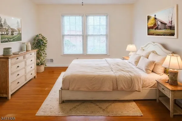 a spacious bedroom with a bed and a painting on the wall