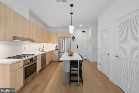 a kitchen with granite countertop a stove a sink and a refrigerator