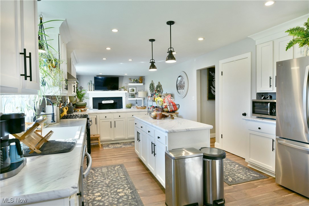5558 Pierce Road Northwest Warren, OH 44481 - Photo 18 of 50 Kitchen featuring white cabinets, stainless steel appliances, pendant lighting, and a kitchen island