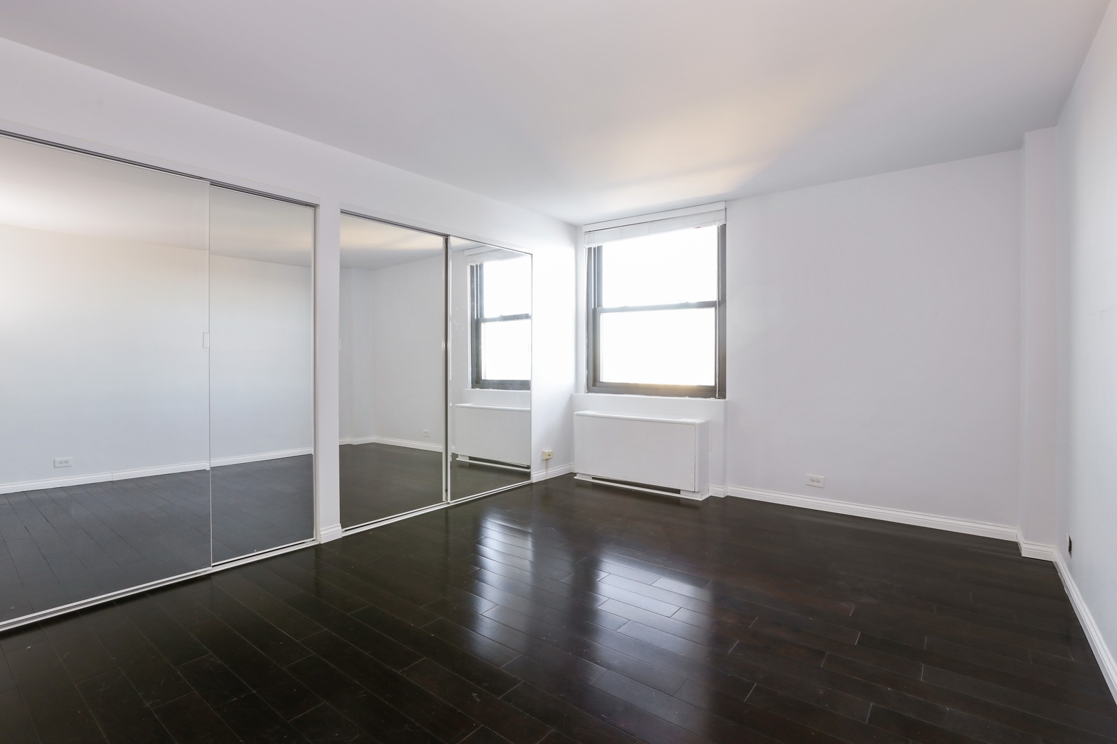 5701 North Sheridan Road, Unit 22H Chicago, IL 60660 - Photo 7 of 10 a view of an empty room with wooden floor and a window