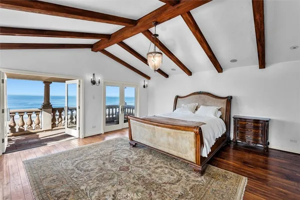 a spacious bedroom with a bed a fireplace and a flat screen tv