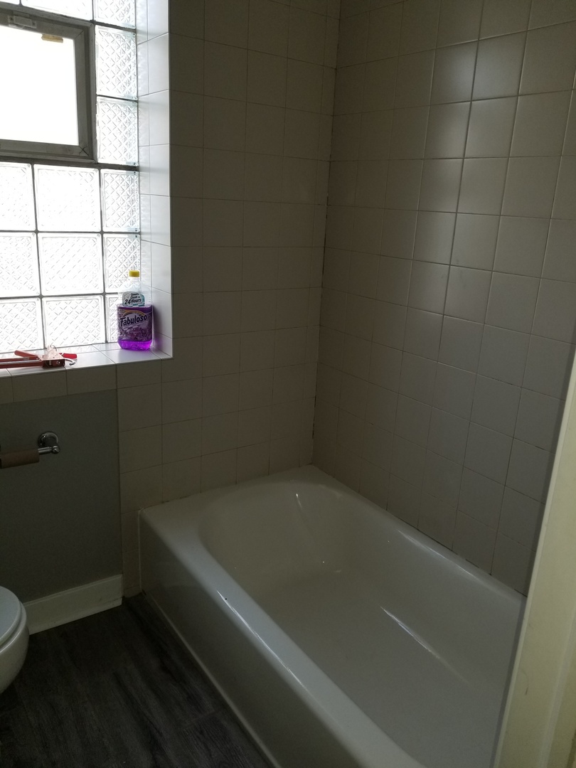 4335 West Irving Park Road, Unit 106 Chicago, IL 60641 - Photo 12 of 12 a bath tub sitting next to a window