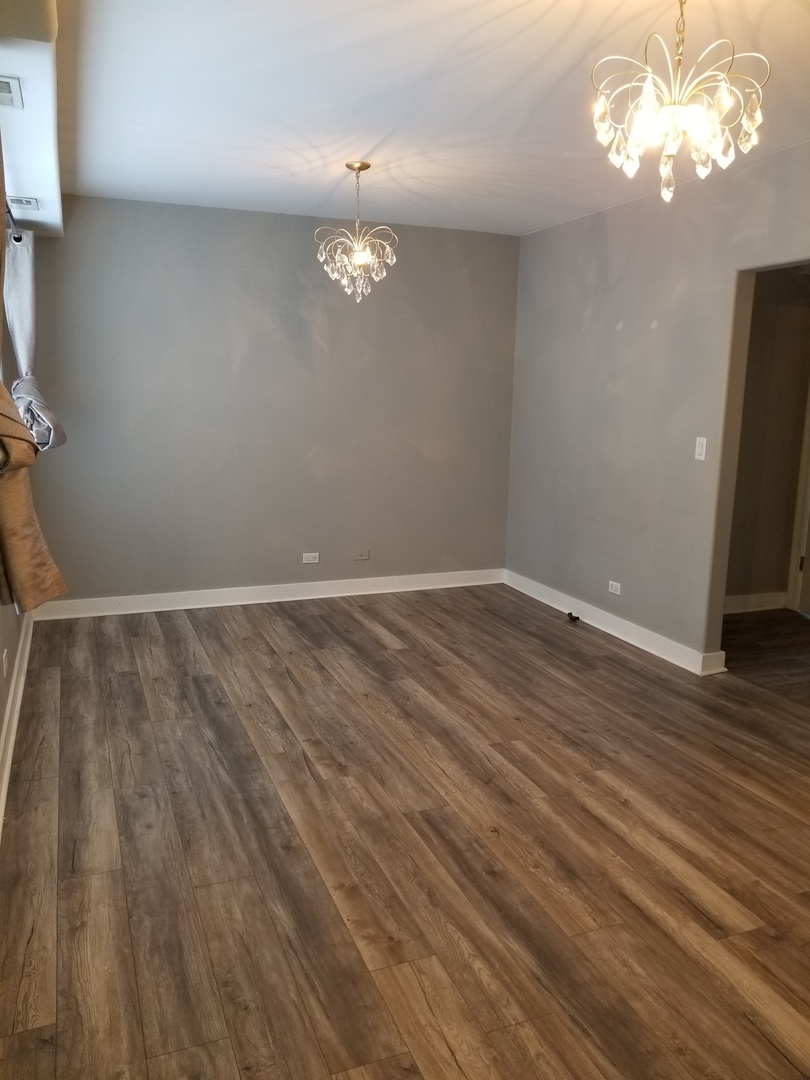 4335 West Irving Park Road, Unit 106 Chicago, IL 60641 - Photo 3 of 12 wooden floor in an empty room with a window