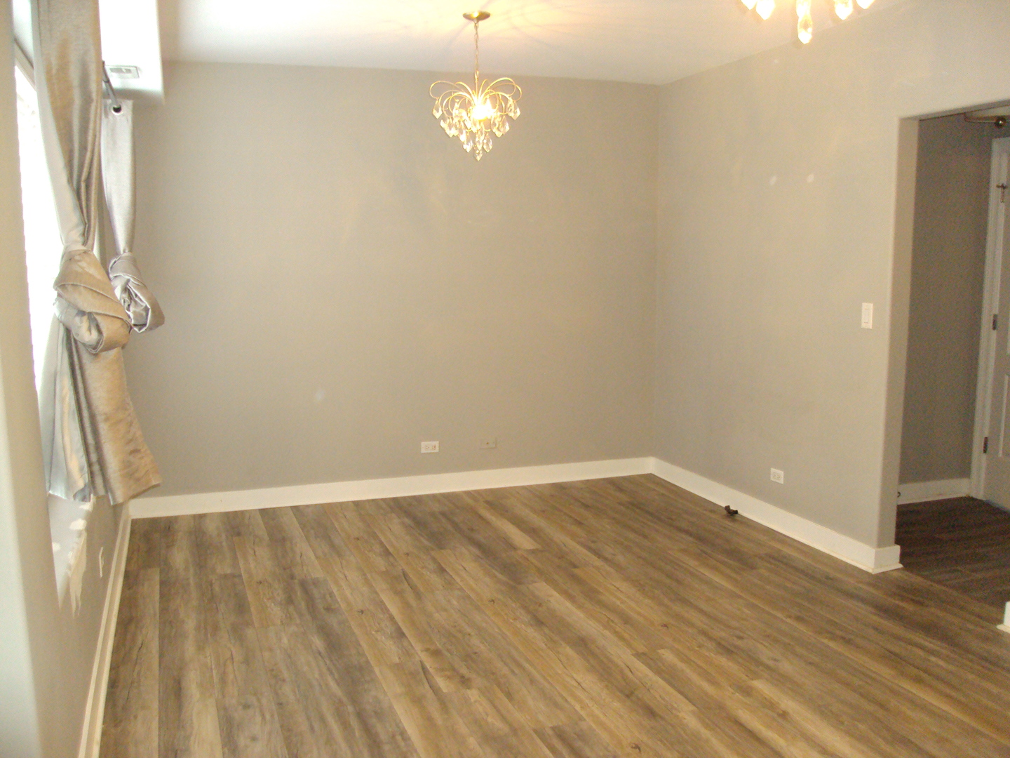 4335 West Irving Park Road, Unit 106 Chicago, IL 60641 - Photo 4 of 12 wooden floor in an empty room with a window