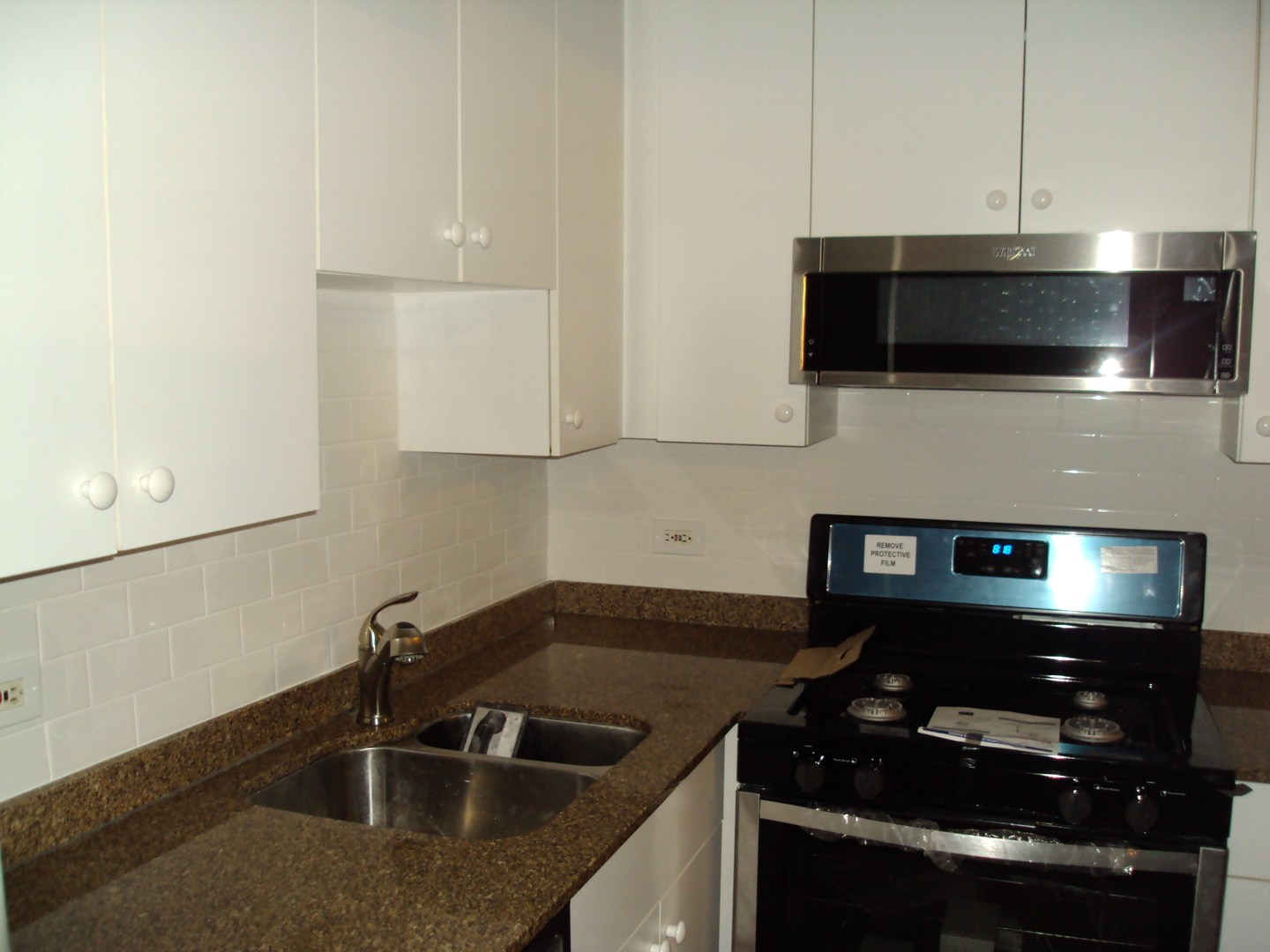 4335 West Irving Park Road, Unit 106 Chicago, IL 60641 - Photo 5 of 12 a kitchen with a sink and stainless steel appliances