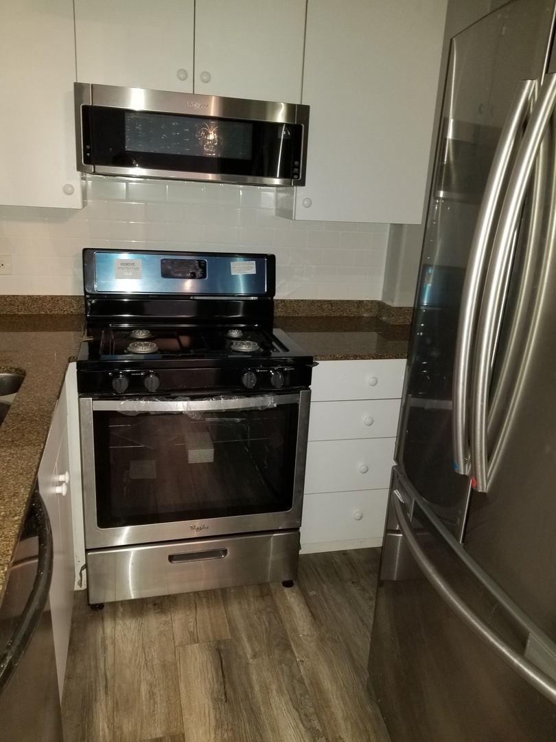 4335 West Irving Park Road, Unit 106 Chicago, IL 60641 - Photo 6 of 12 a stove top oven sitting inside of a kitchen