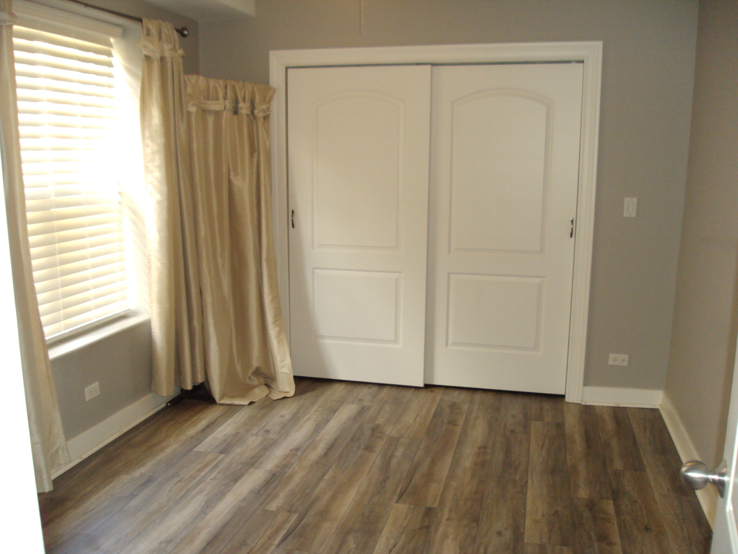 4335 West Irving Park Road, Unit 106 Chicago, IL 60641 - Photo 8 of 12 an empty room with wooden floor and windows