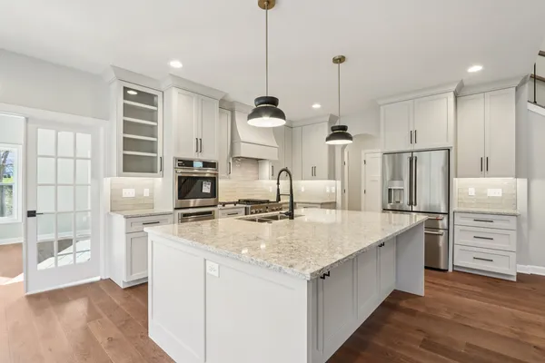 a kitchen with stainless steel appliances granite countertop a sink stove and refrigerator