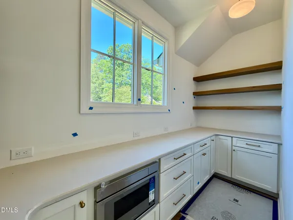 a view of an empty room with a fireplace and a window