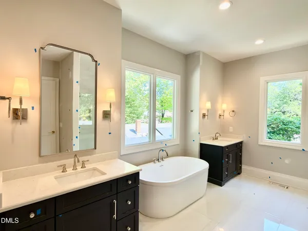 a spacious bathroom with a tub sink shower and a mirror