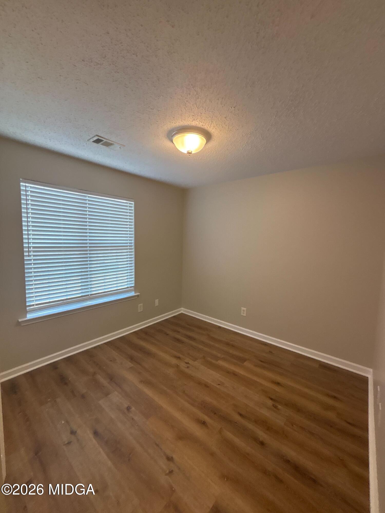 404 Dunmurry Place Warner Robins, GA 31093 - Photo 12 of 18 a view of an empty room with wooden floor and a window