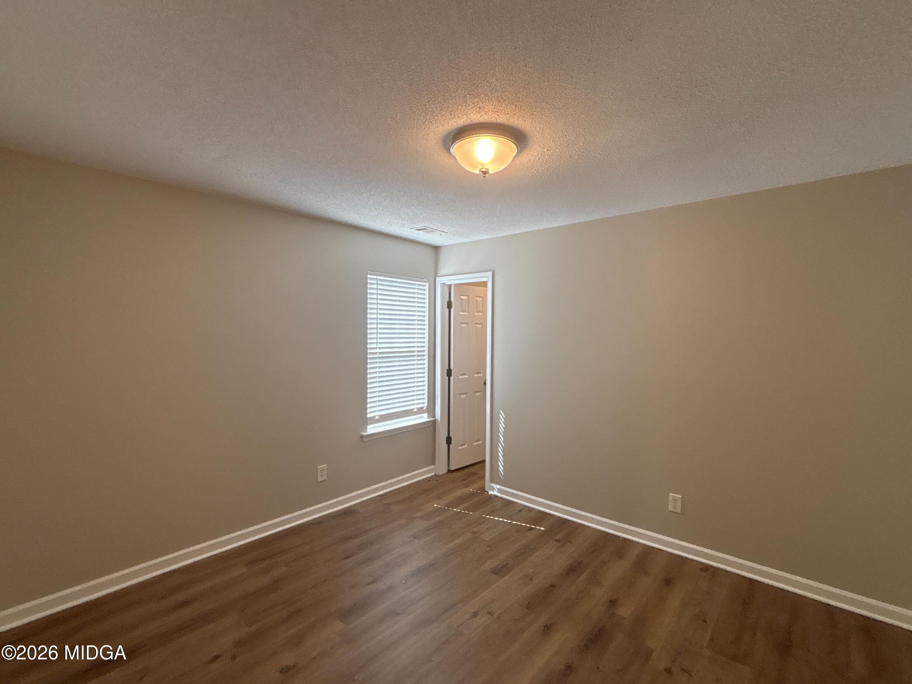 404 Dunmurry Place Warner Robins, GA 31093 - Photo 14 of 18 an empty room with wooden floor and windows