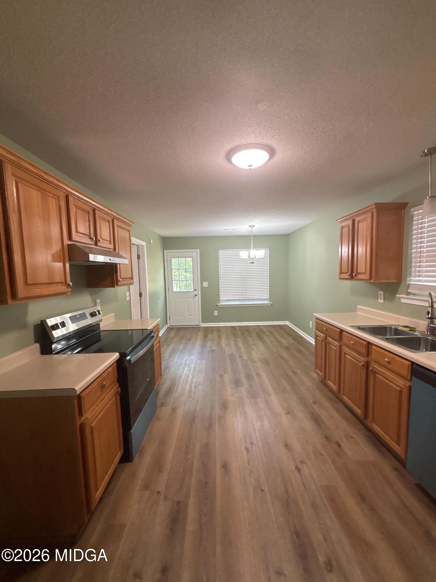 404 Dunmurry Place Warner Robins, GA 31093 - Photo 3 of 18 a kitchen with stainless steel appliances granite countertop a stove a sink dishwasher and a microwave oven with wooden floor